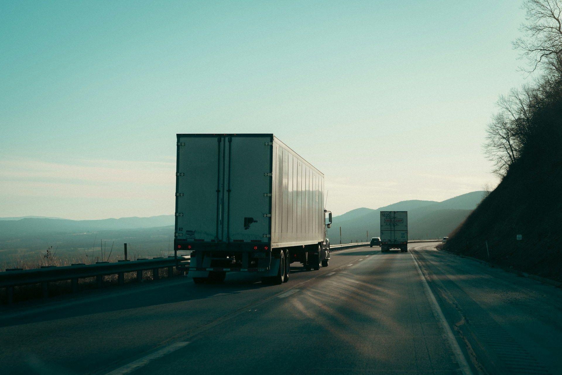 Trucks on an open highway at dusk